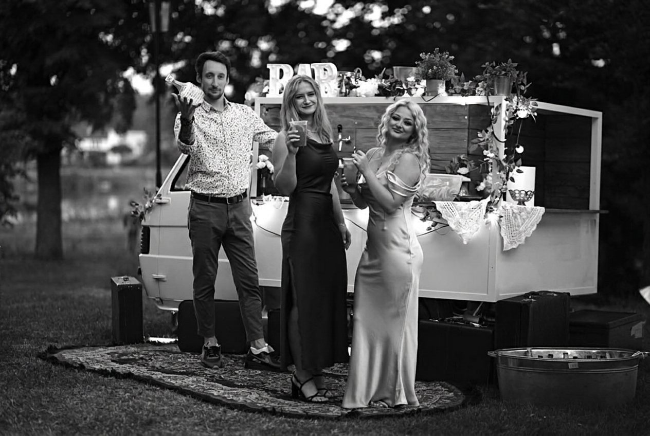 Goście eventu przy włoskim vanie - fotografia czarno-biała