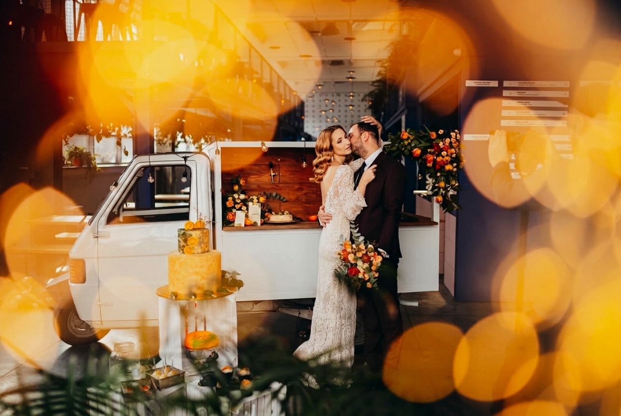 Para młoda przy vanie w wieczornym świetle girland